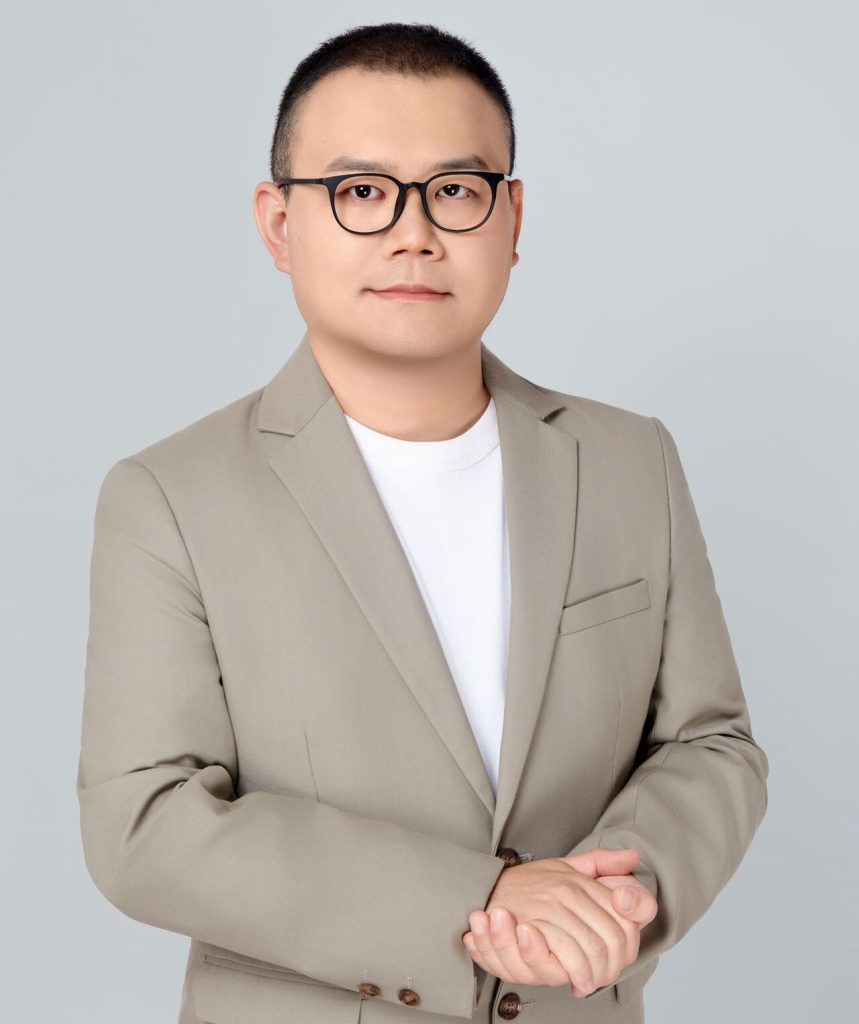 A photo of Sibo Chen wearing a tan blazer.